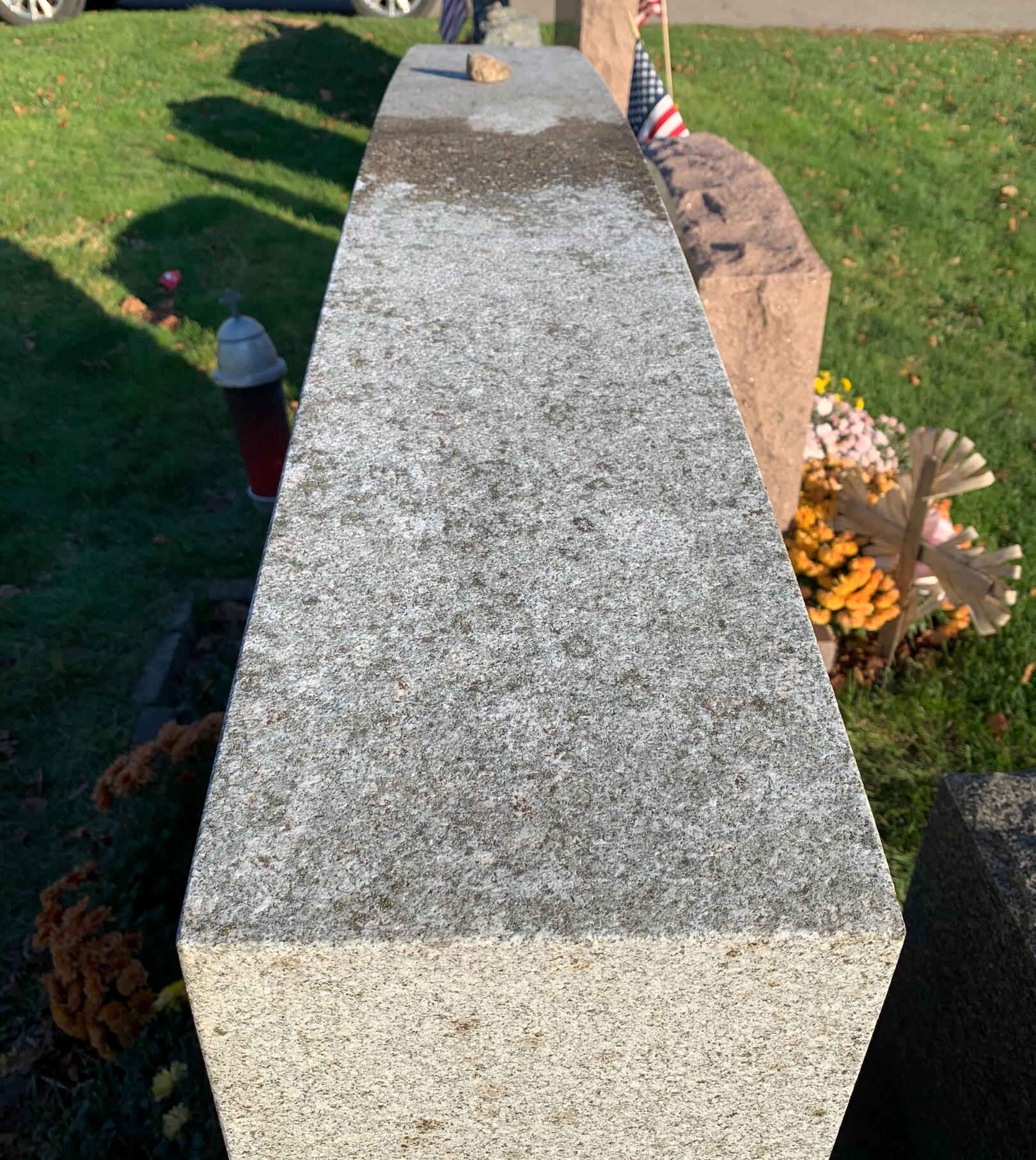 The same granite monument top after professional cleaning — biological growth removed, stone restored